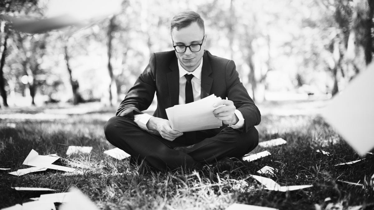 businessman-sitting-with-lot-scattered-paperworks_33263100