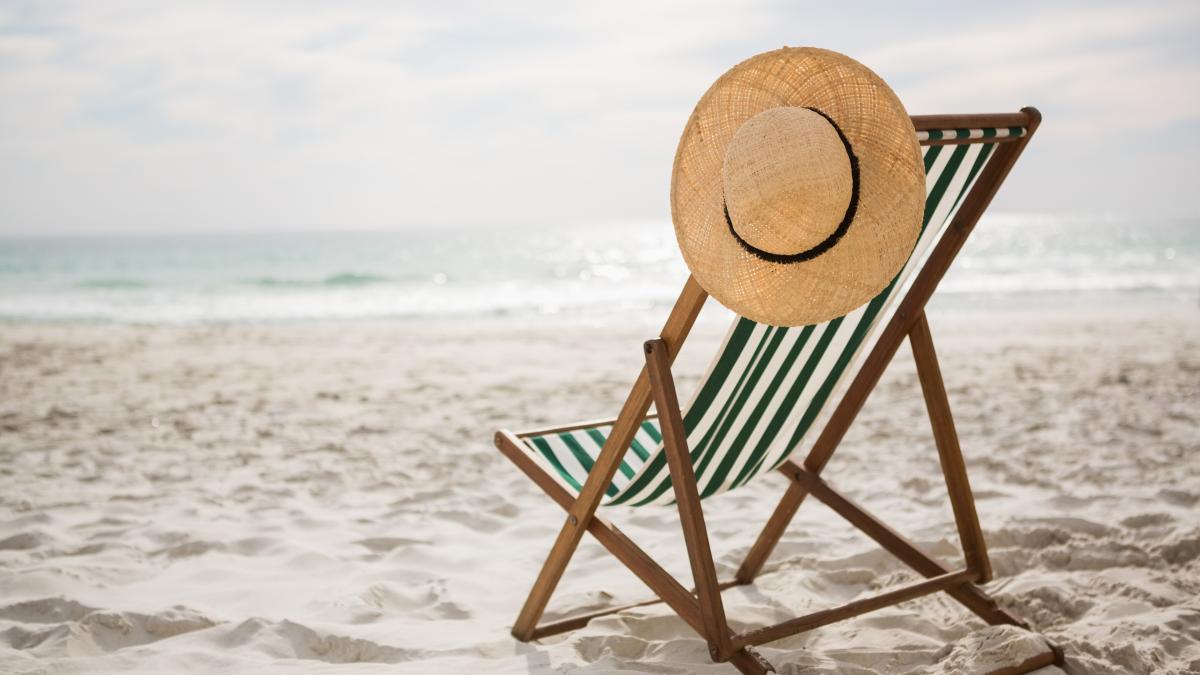straw-hat-kept-empty-beach-chair_69949300