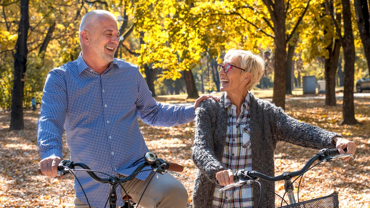 happy-elderly-couple-riding-bicycle-park-autumn_44902900