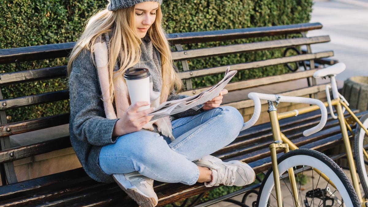charming-woman-reading-newspaper-bench_78348700