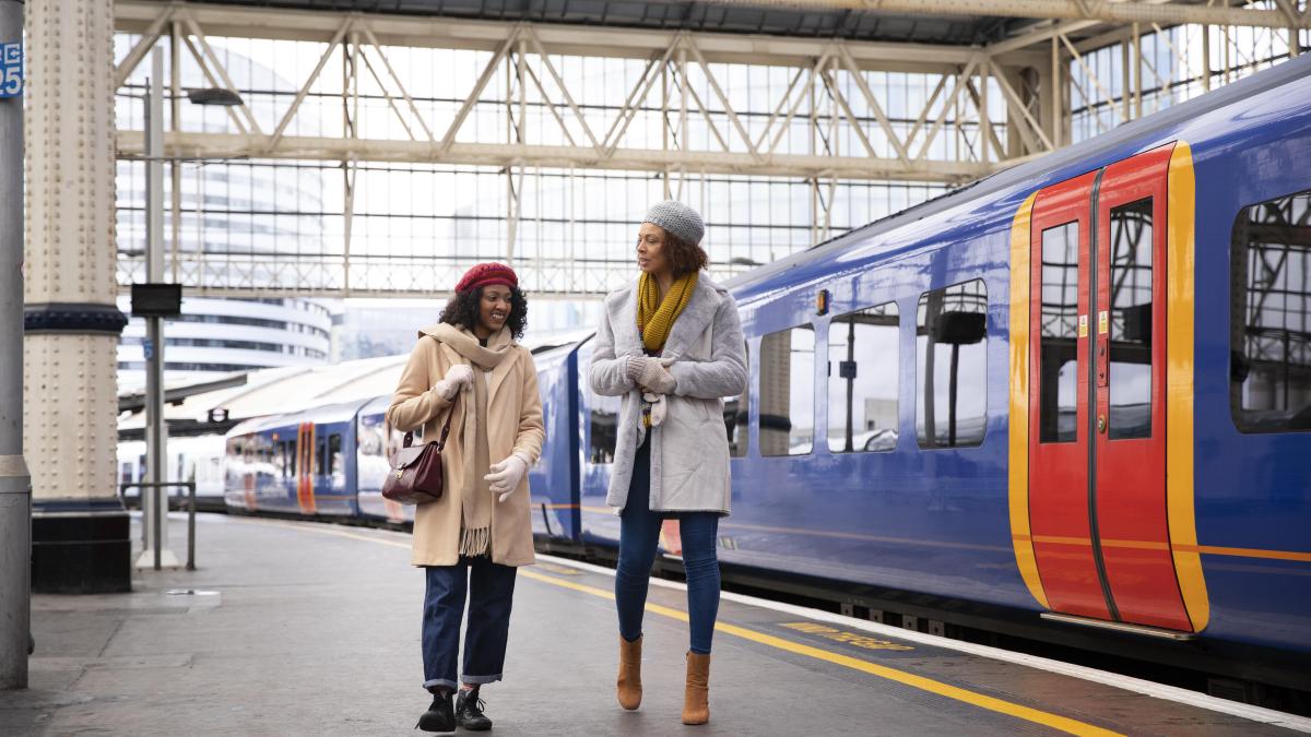 full-shot-smiley-women-train-station_60109000