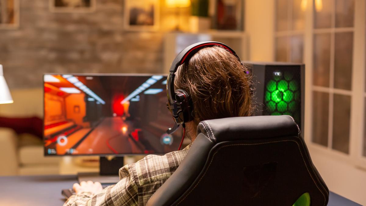 back-view-gamer-male-playing-shooter-his-powerful-pc-computer-late-night-living-room_44300600