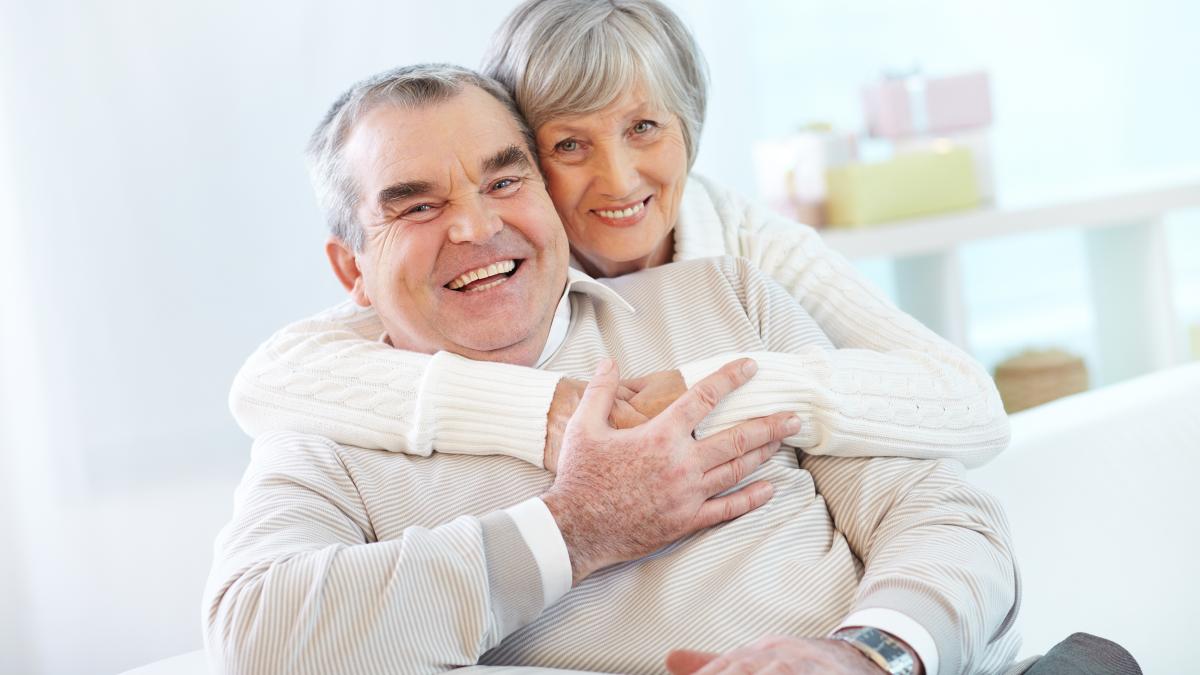 senior-couple-hugging-home_68566100