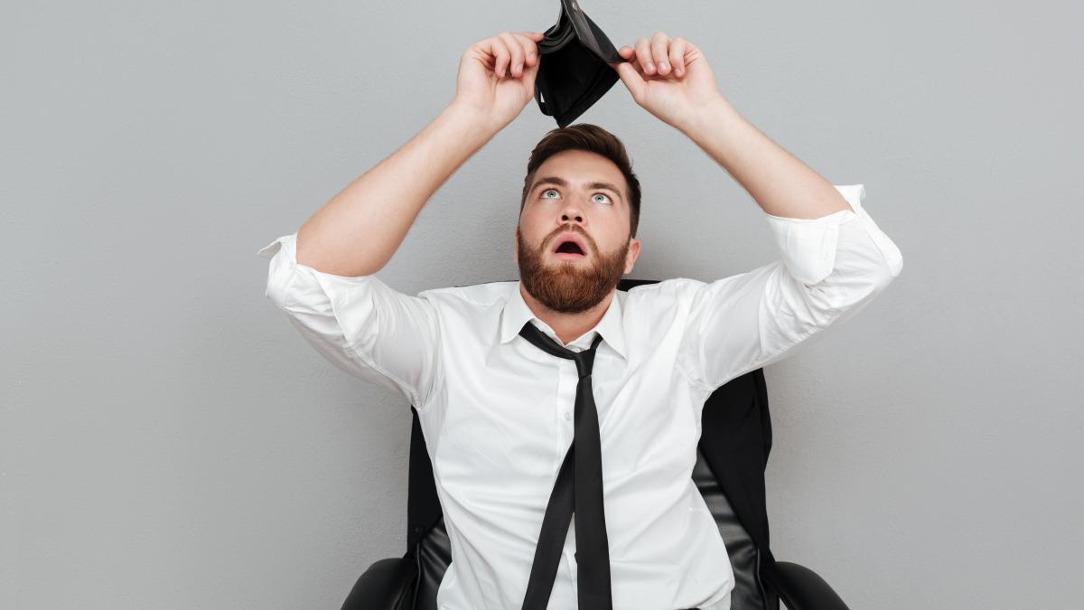 frustrated-surprised-bearded-man-white-shirt-showing-empty-wallet_12574200