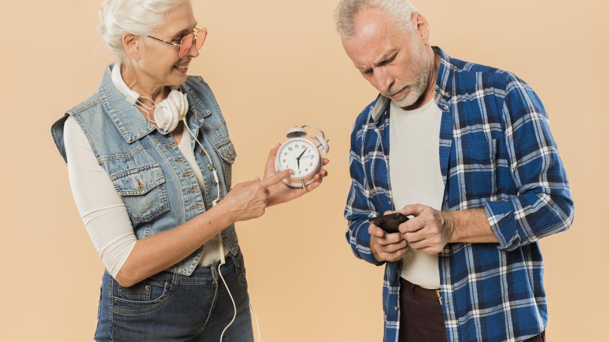 cool-senior-couple-with-alarm-clock-smartphone_60063100