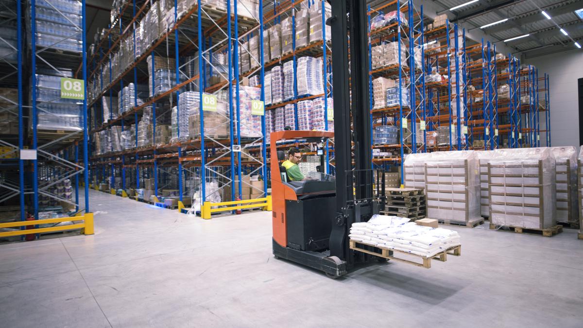 worker-operating-forklift-machine-relocating-goods-large-warehouse-center_71456500