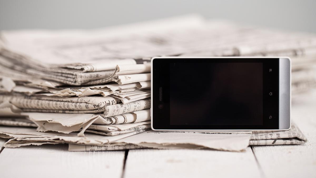 pile-newspapers-with-smartphone-it_59834200