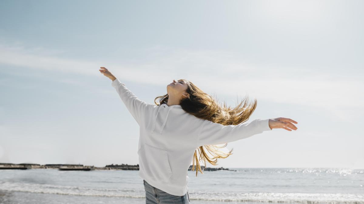 young-woman-enjoying-ocean-breeze_81132100