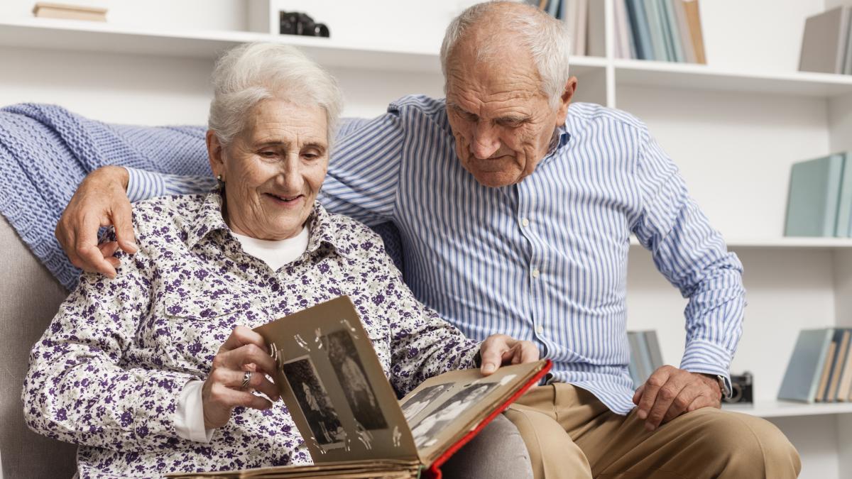 mature-couple-looking-into-photo-album_08709200