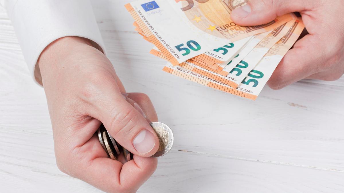 man-holding-bank-notes-coins_26665800