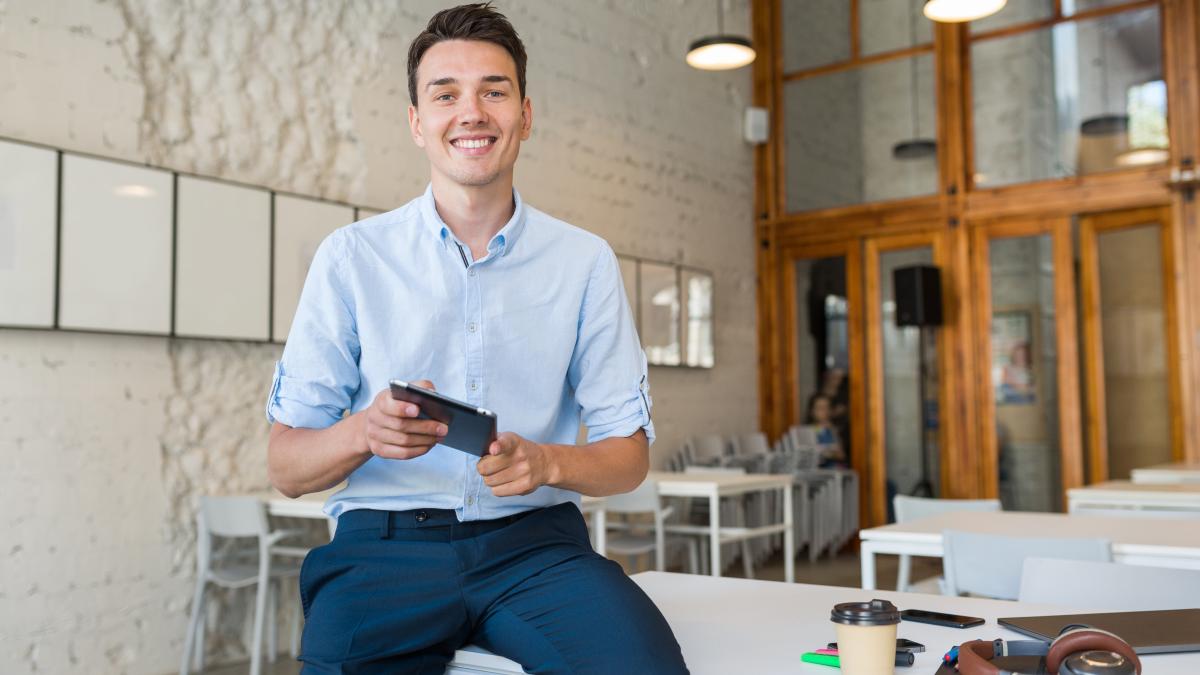 young-stylish-smiling-man-co-working-office-startup-freelancer-holding-using-tablet_56375800