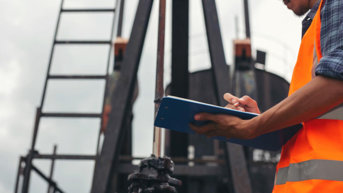 workers-standing-checking-beside-working-oil-pumps_91285000
