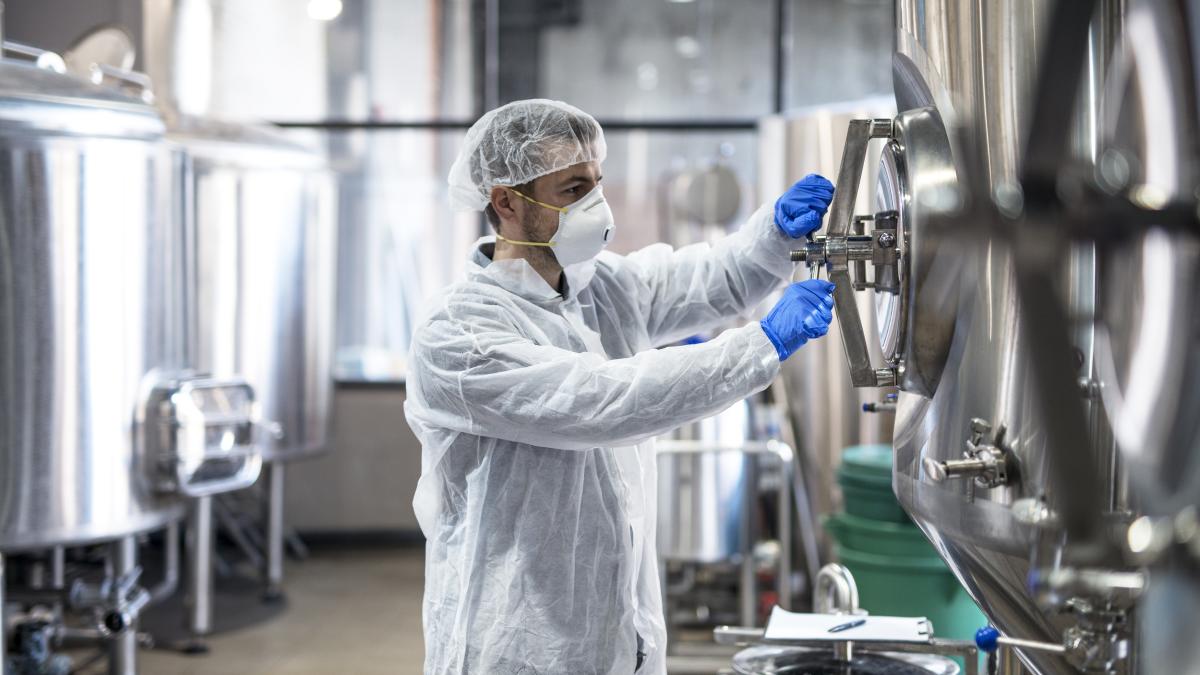 technologist-protective-uniform-wearing-hairnet-mask-goggles-gloves-closing-industrial-tank-reservoir_44244300