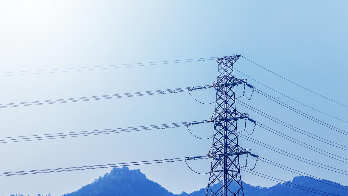 electricity-transmission-pylon-silhouetted-against-blue-sky-d_67964000