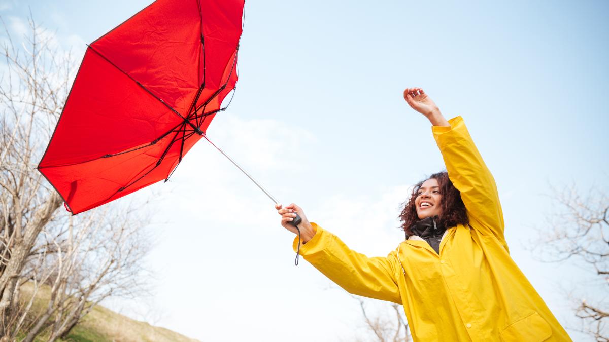 woman-catching-flying-umbrella_27419200