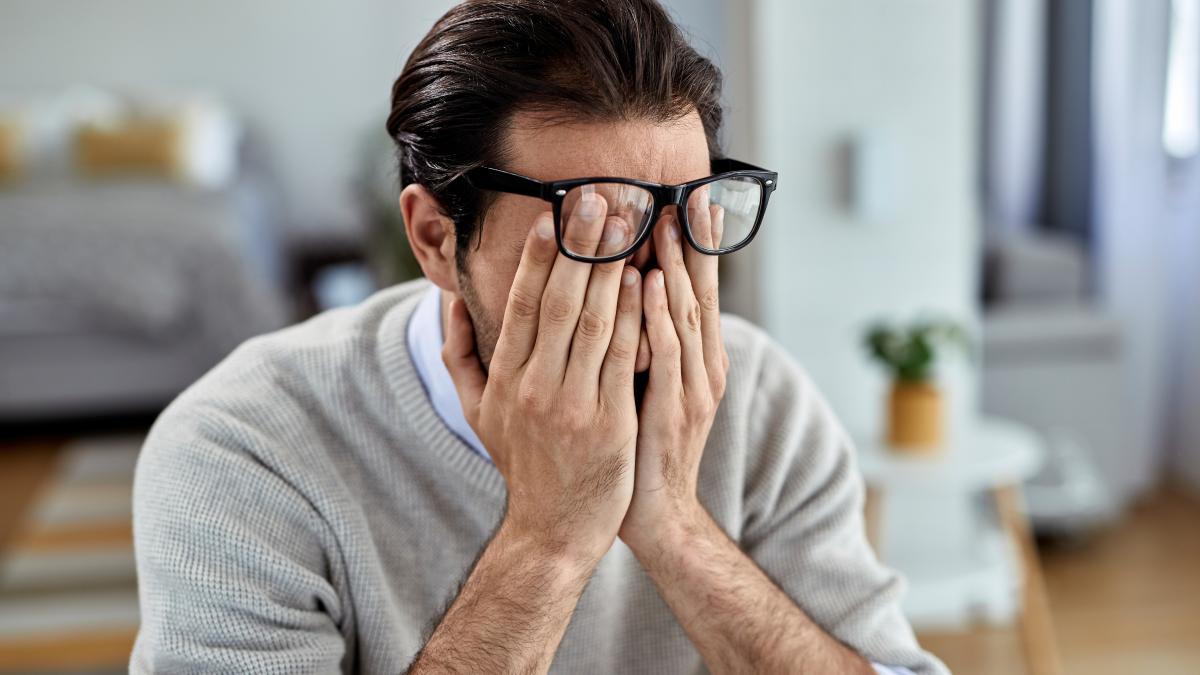 young-businessman-feeling-exhausted-while-working-home_98817700