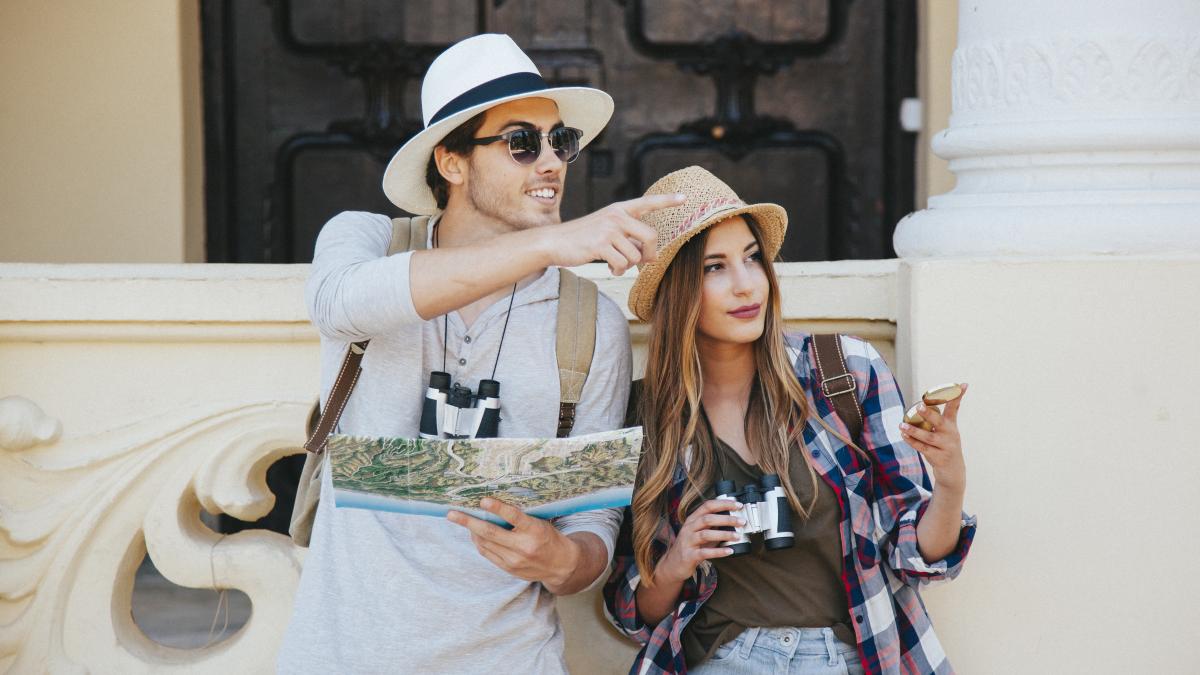 couple-travelers-pointing-directions_20955500