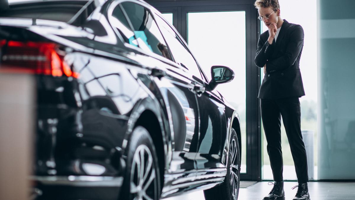 man-looking-car-thinking-purchase_98580100