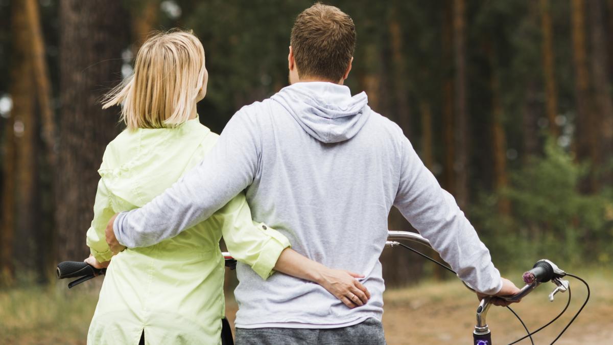 back-view-hugging-couple-with-forest-background_49166200