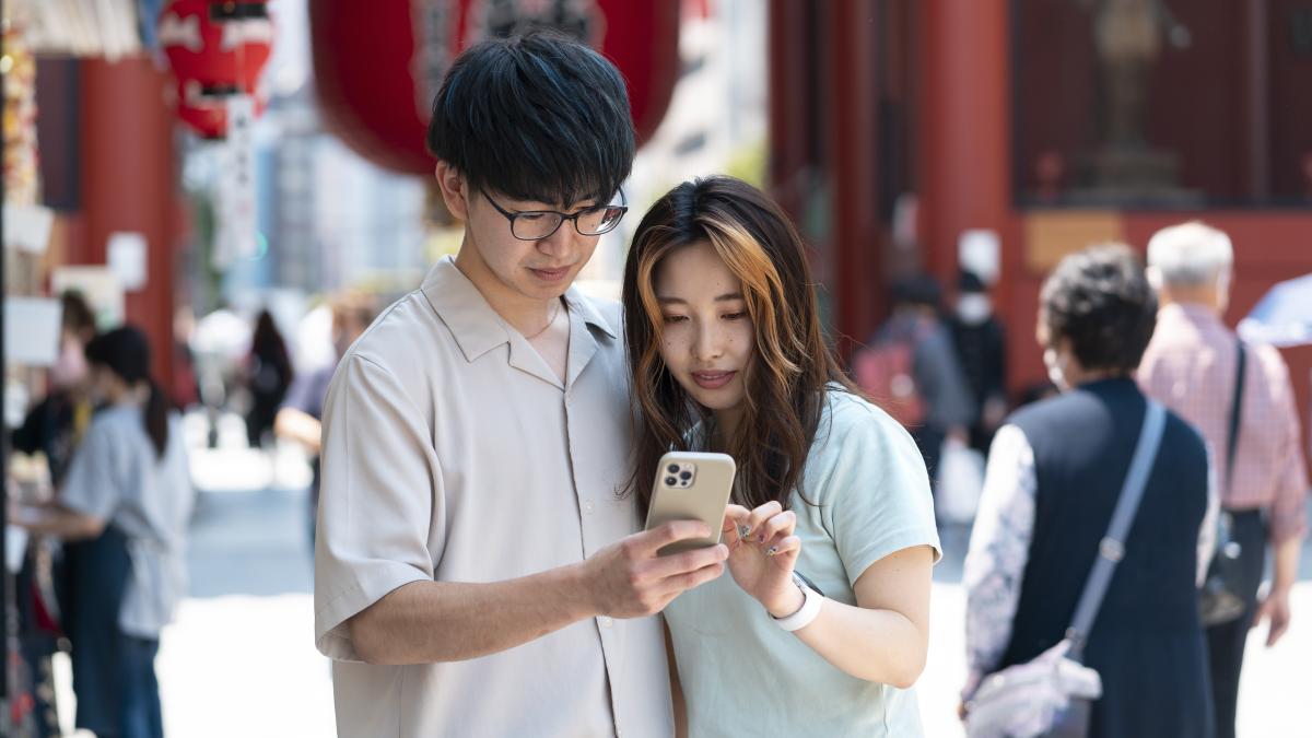 medium-shot-friends-holding-smartphone_00384800