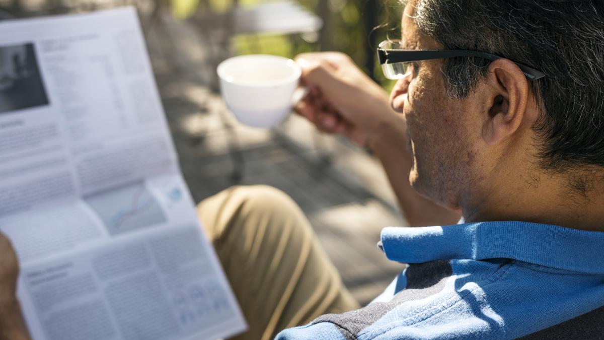 man-relaxing-while-reading-newspaper-drinking-coffee_71644400