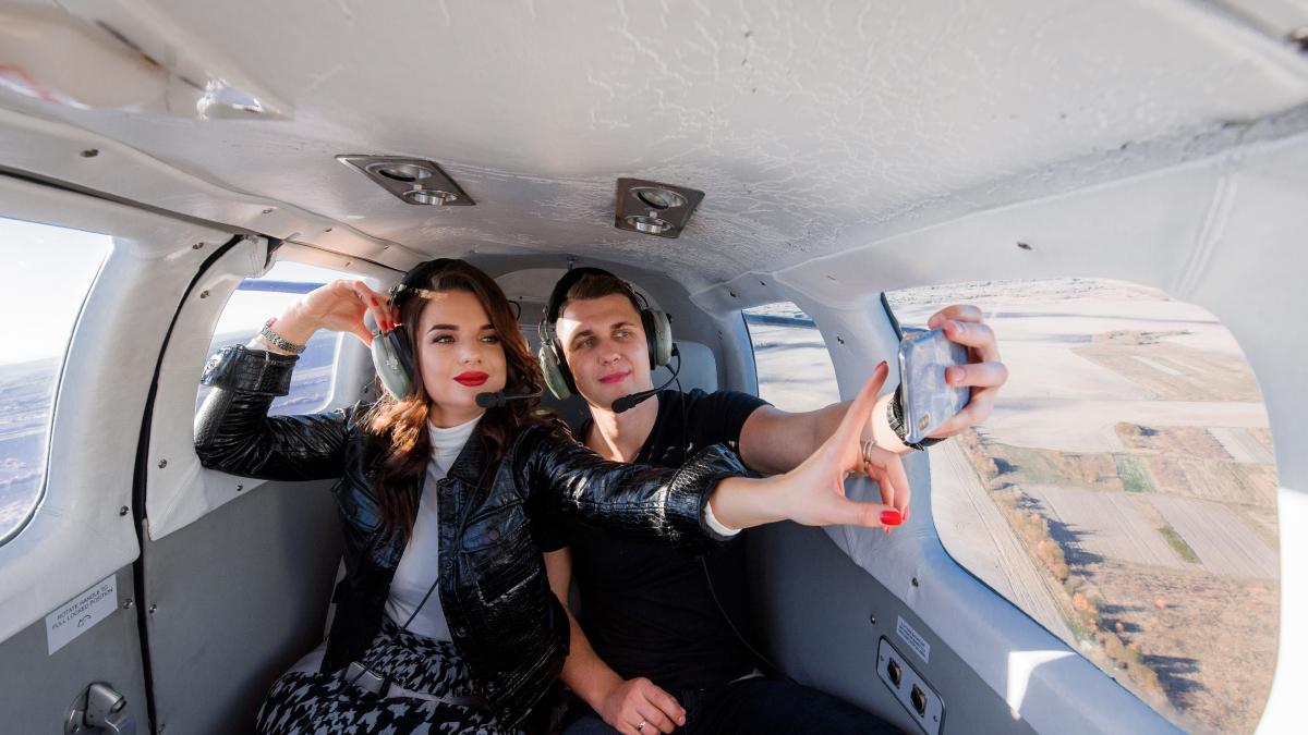 beautiful-couple-is-making-selfie-inside-helicopter-with-breathtaking-scenery-out-window_53879900