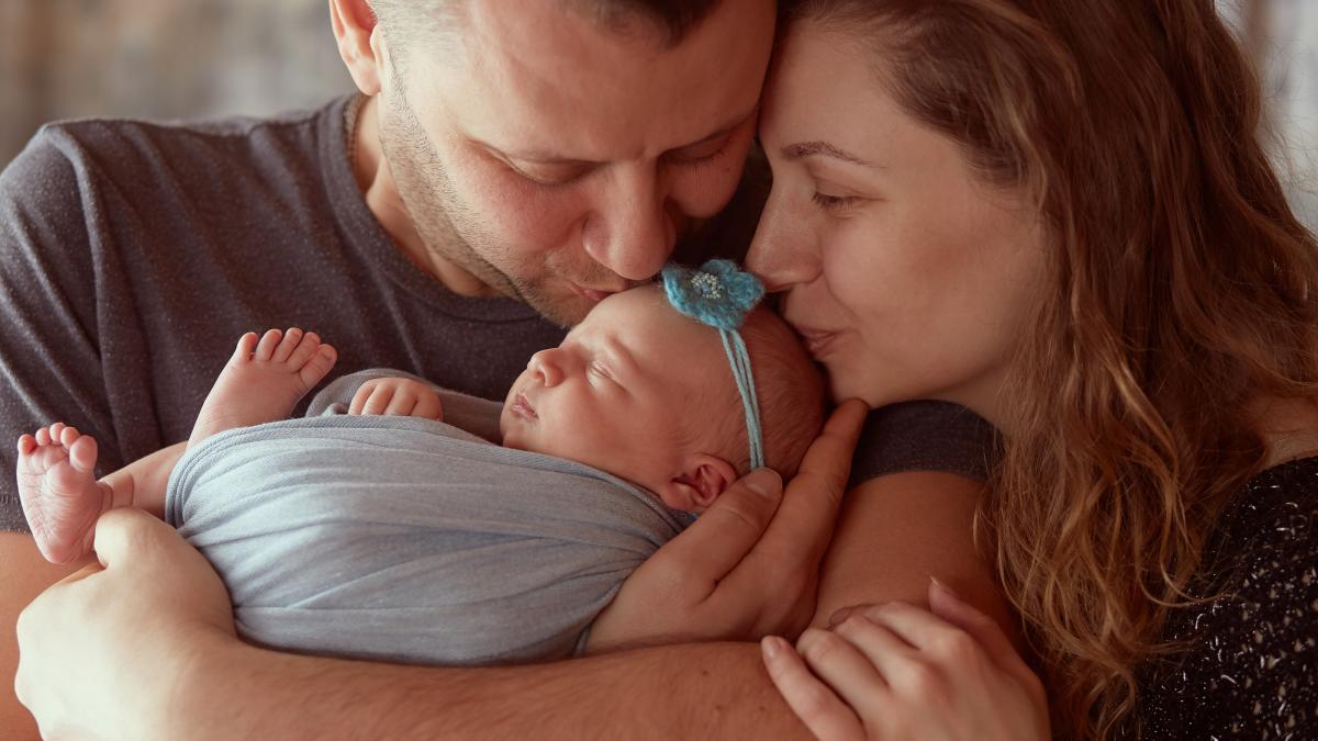 mother-father-embracing-their-daughter_21307900