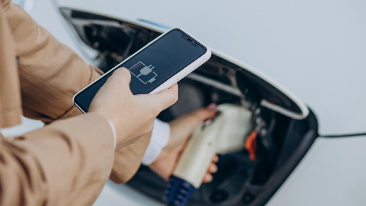 woman-holding-charger-charging-electric-car-close-up_37855000
