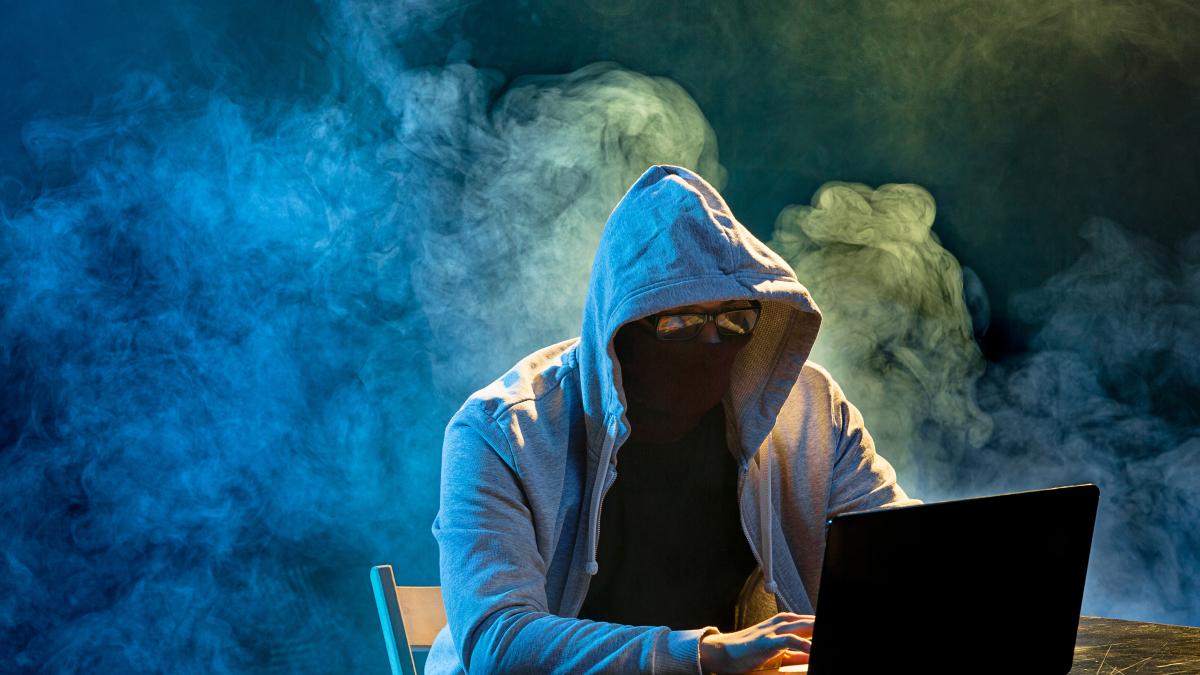 hooded-computer-hacker-stealing-information-with-laptop-1_81698900