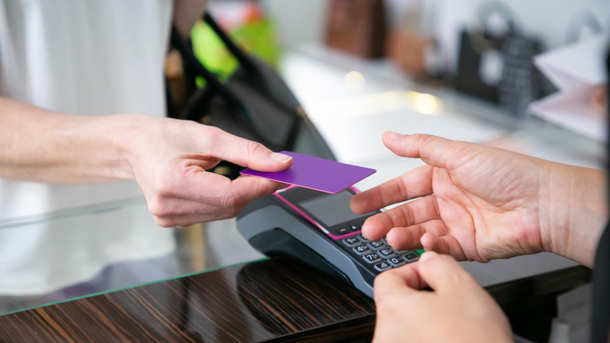 customer-giving-credit-card-cashier-desk-with-pos-terminal-payment-cropped-shot-closeup-hands-shopping-concept_41264400