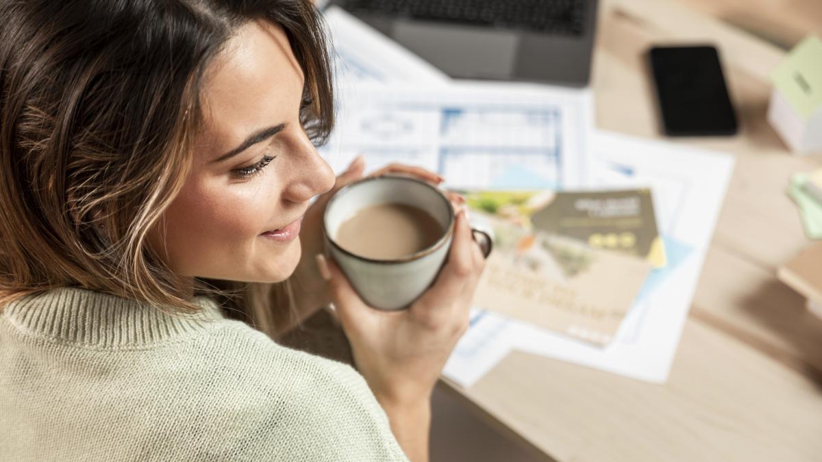 close-up-smiley-woman-holding-coffee-cup_01549100