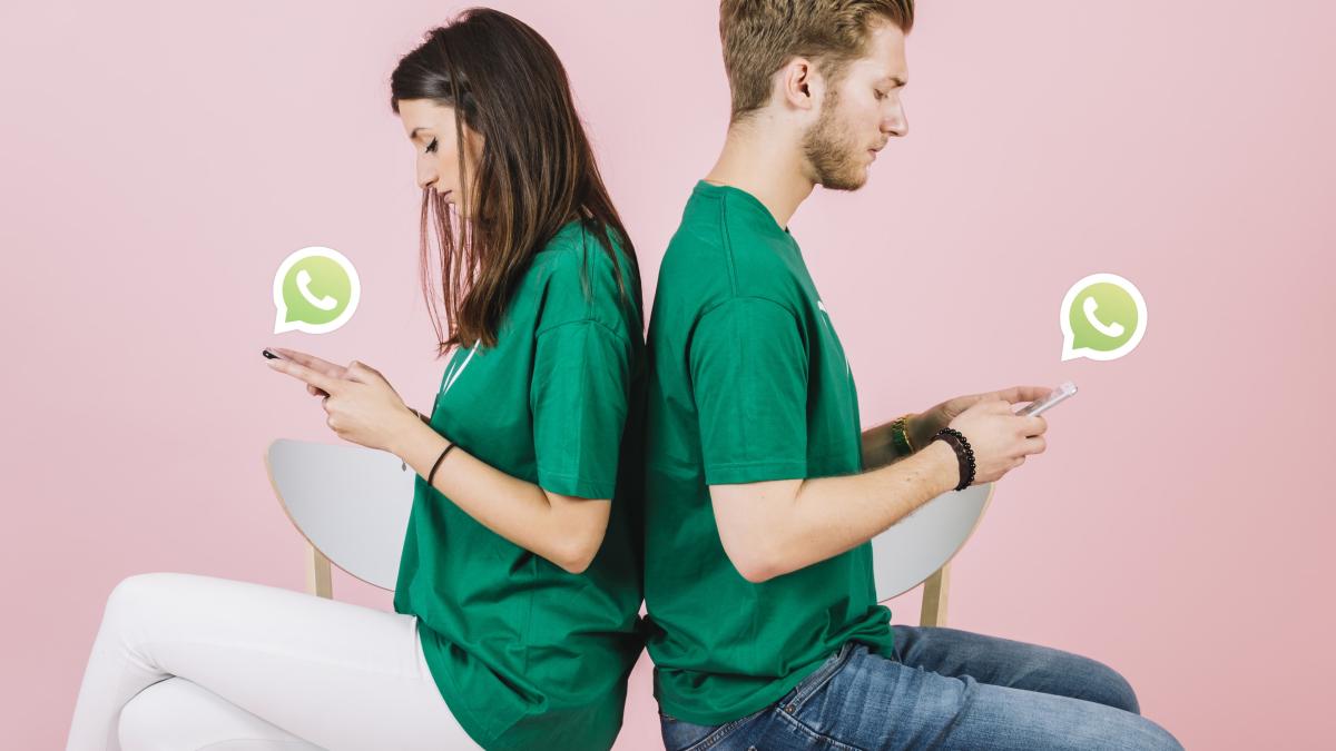 young-couple-sitting-back-back-using-whatsapp-smartphone_43262200