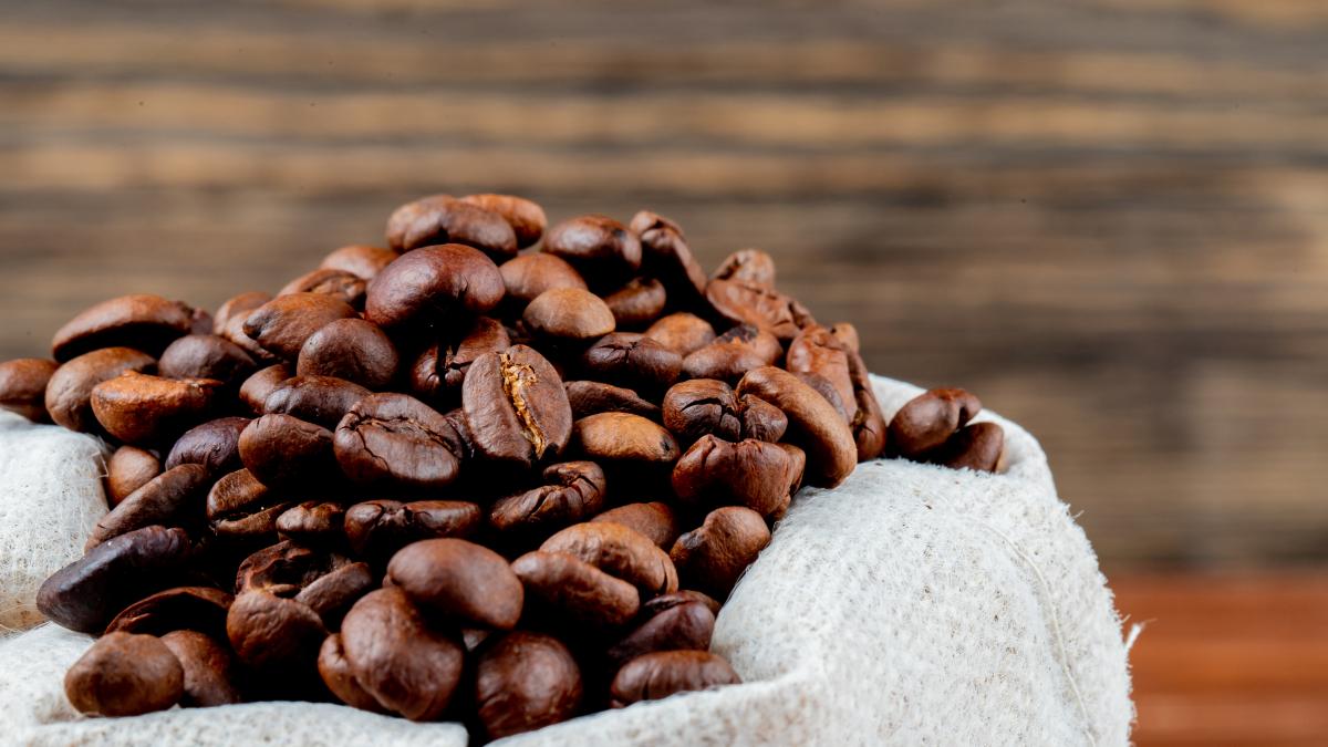 side-view-brown-coffee-beans-sack-rustic-table_84527000