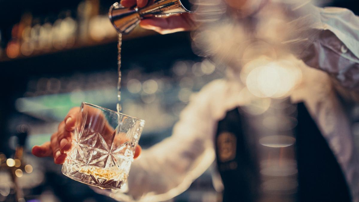 handsome-bartender-making-drinking-cocktails-counter_37595100