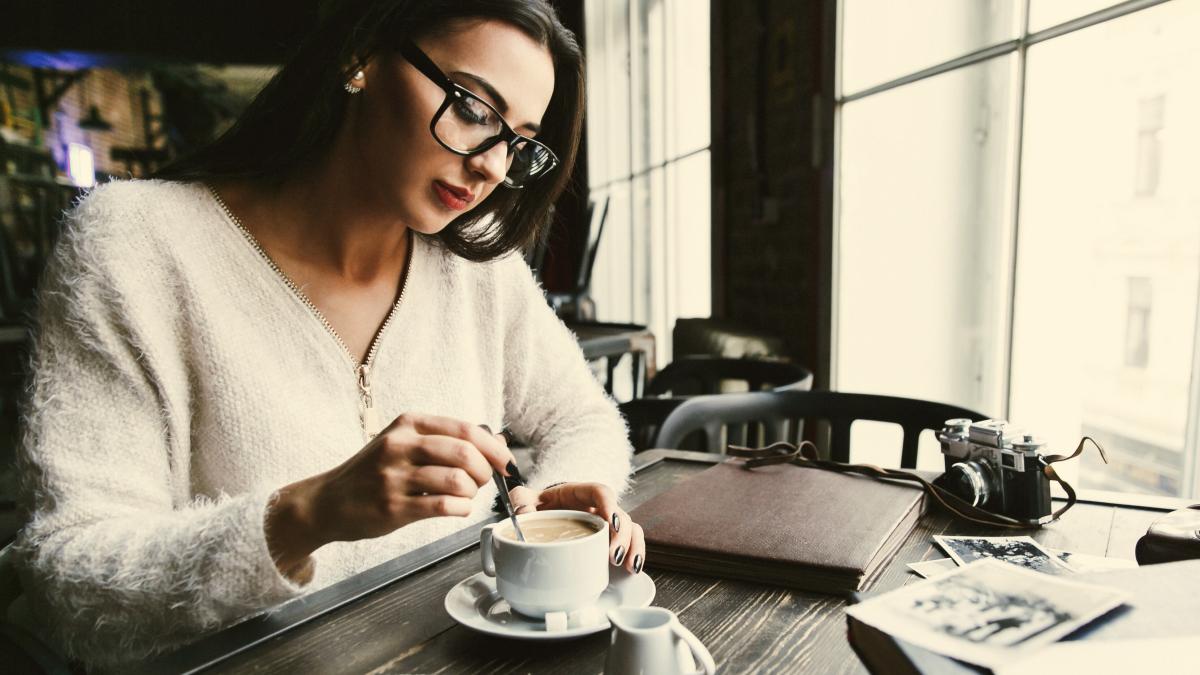 thoughtful-woman-stirs-sugar-cup-coffee_14064800