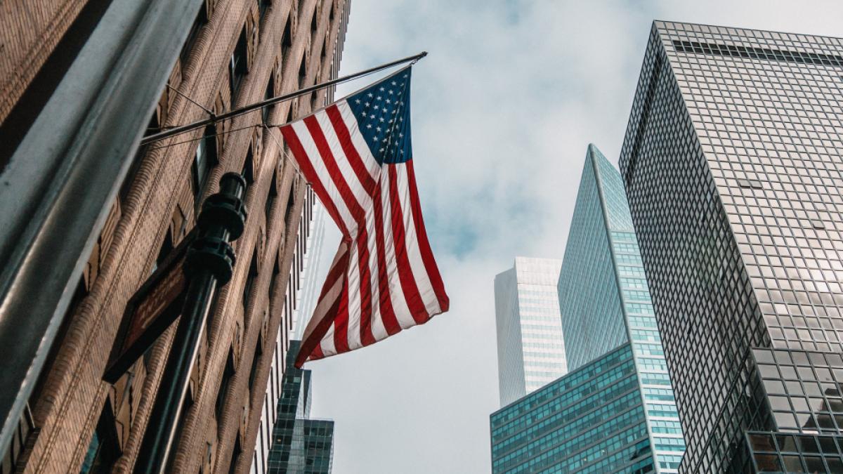 usa-united-states-america-flag-flagpole-near-skyscrapers-cloudy-sky_59320200