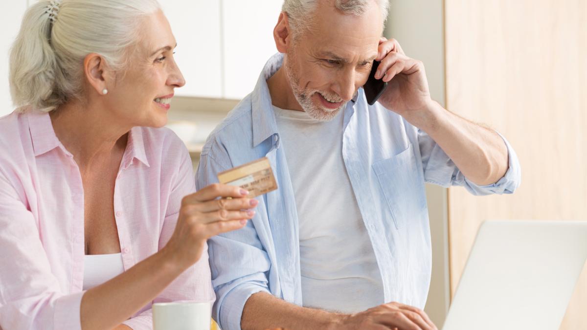 smiling-mature-loving-couple-family-using-laptop-holding-credit-card_91524300