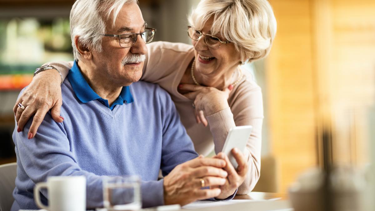 senior-man-text-messaging-mobile-phone-while-wife-is-talking-him-home_94574600