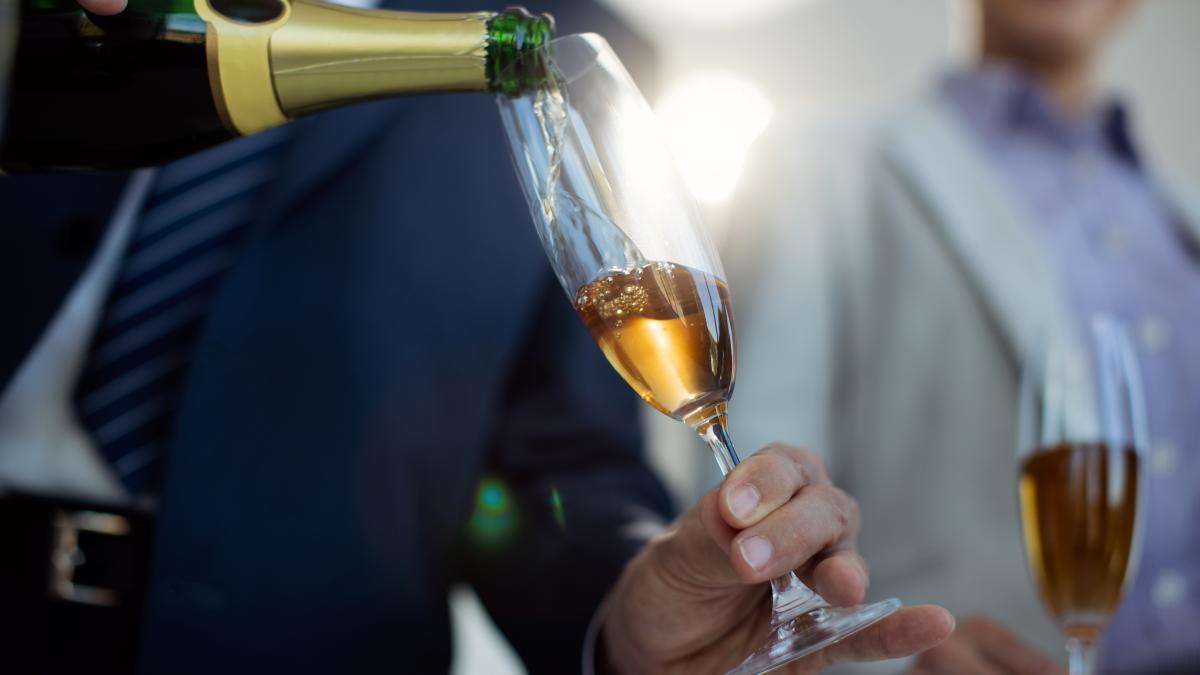 closeup-businessman-pouring-champagne-during-office-party_41609900