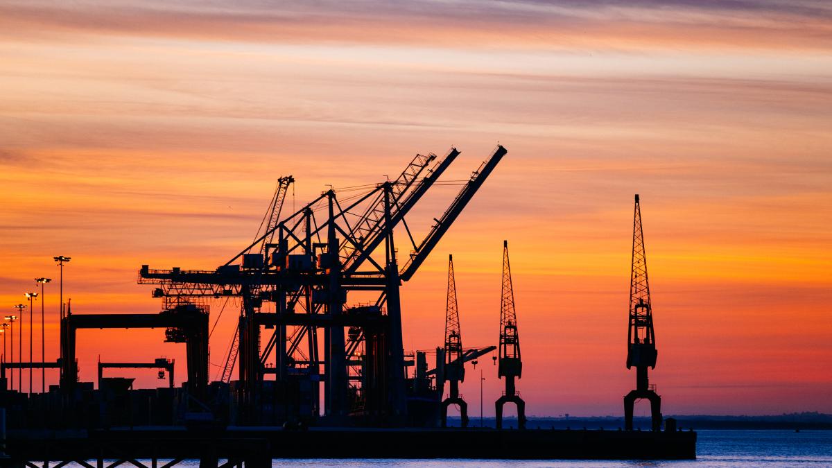beautiful-silhouette-port-machinery-during-sunset_24033400