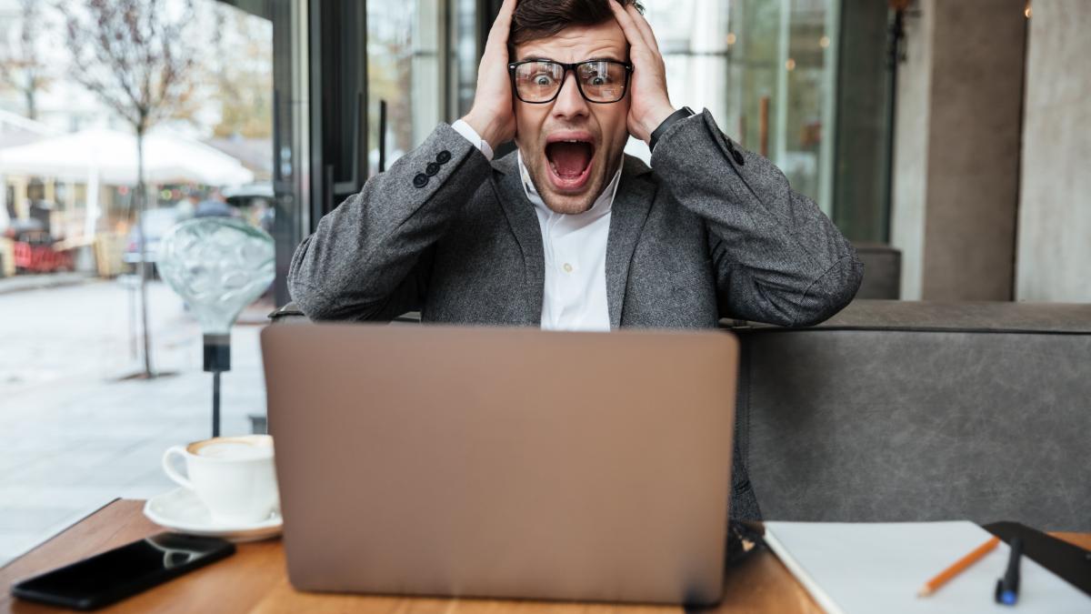 worried-screaming-businessman-eyeglasses-sitting-by-table-cafe-holding-head_27248800
