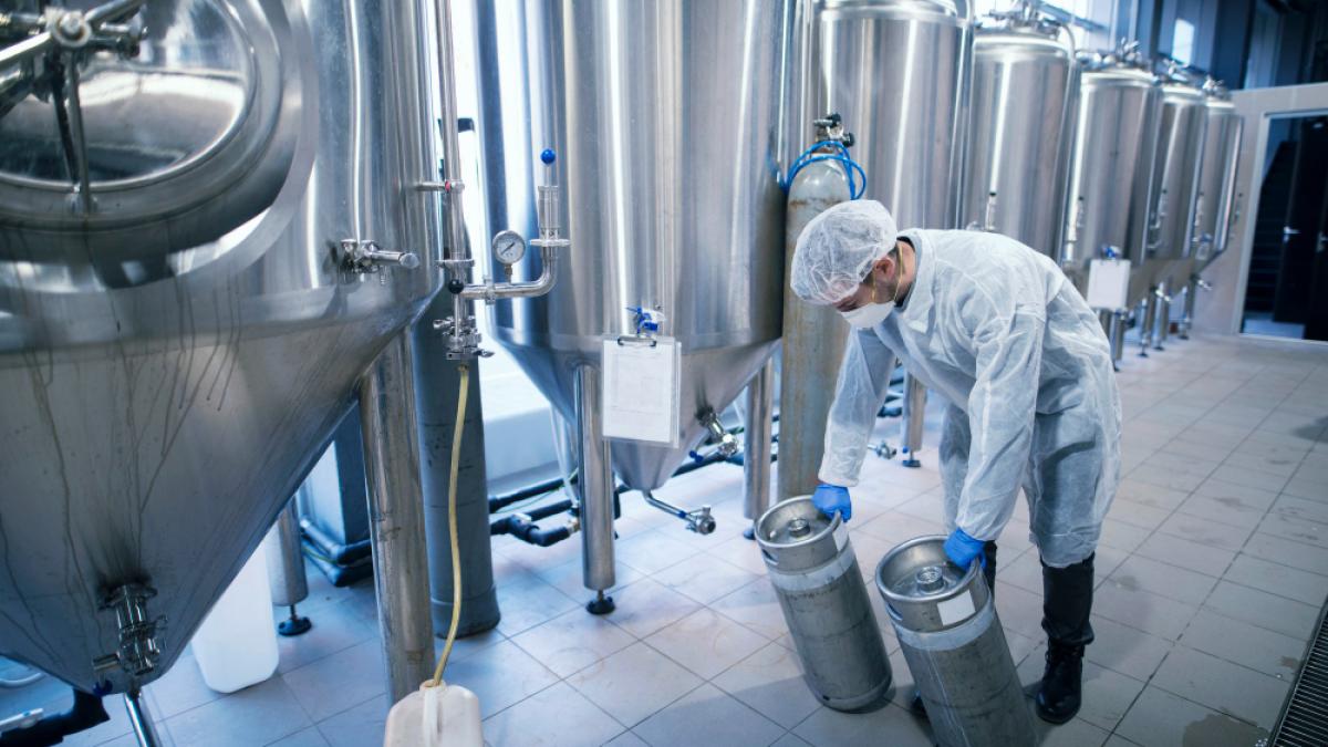 worker-protective-suit-carrying-chemicals-metal-reservoirs_54979700