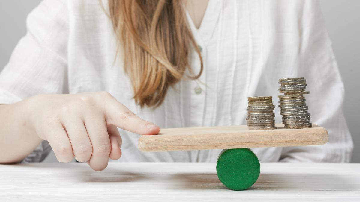 woman-holding-her-finger-balance-with-coins_87371500