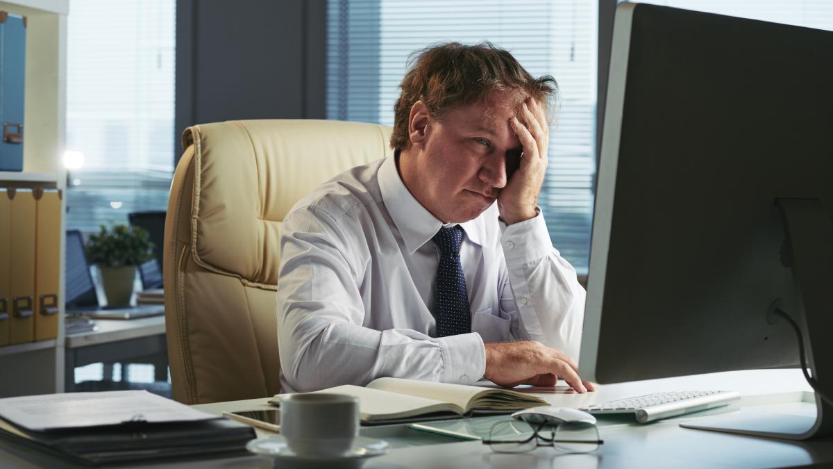 stressed-man-with-headache-working-early-morning-his-office_36650800