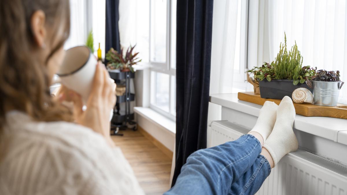 close-up-woman-sitting-near-heater_39700500