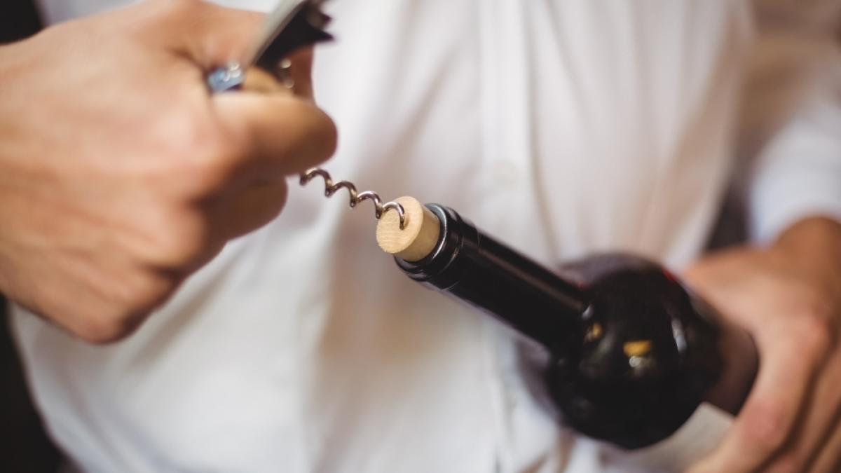 mid-section-bar-tender-opening-bottle-wine_71531300