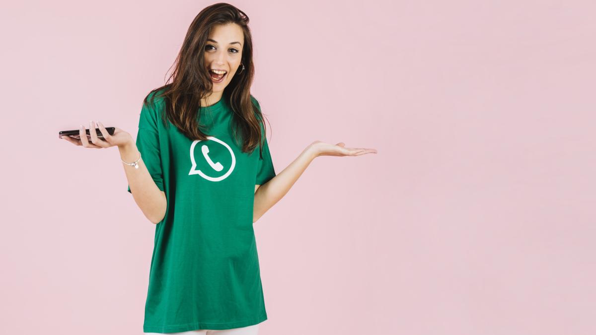 happy-woman-with-smartphone-shrugging-pink-backdrop_21637800