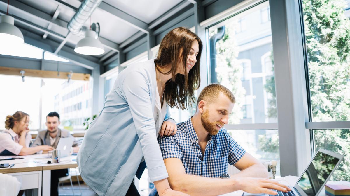 smiling-man-woman-cooperating-laptop_56412400