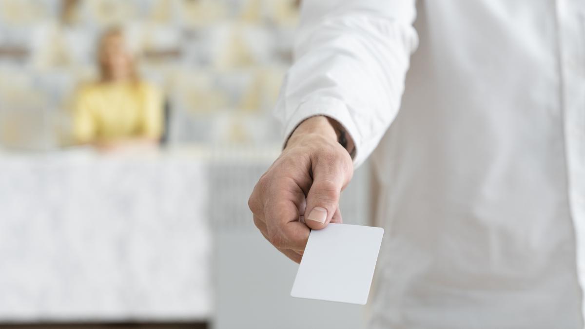 high-angle-hand-holding-blank-business-card_97988400