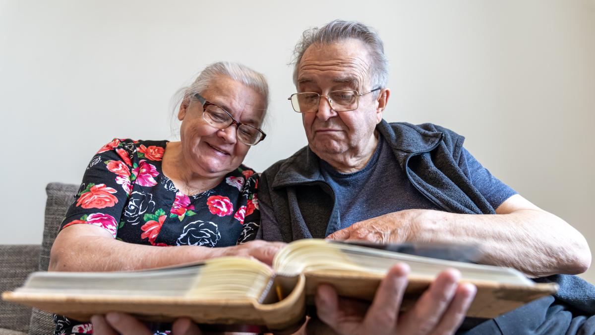 elderly-couple-is-looking-photographs-family-photo-album-1_60771600